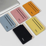 Les produits de diverses couleurs de cuir sont disposés en deux rangées de deux et trois produits, le tout sur une table blanche et à côté d'un ordinateur portable gris.
