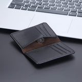 Le produit est ouvert, vide, avec une pièce de monnaie posé dans une poche intérieur, le tout posé devant un ordinateur portable gris métallique sur une table noire.