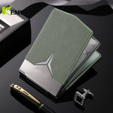 Porte carte bancaire en cuir vert mis sur une table noire autour d'un stylo et d'un accessoire brillant.