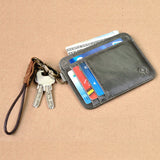 Le porte-cartes en cuir est posé sur un espace marron clair avec des cartes et des billets dedans plus des clés accrochées au modèle.