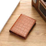 Le porte-cartes marron est à plat sur une table en bois.