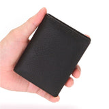 La main gauche d'un homme tient le porte-cartes bancaire en cuir noir dans sa main.