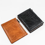 Le porte-cartes en cuir noir est posé à la droite de son équivalent en cuir kaki.