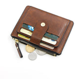 Un porte-cartes en cuir marron est observé du dessus, remplie de cartes, de billets et de quelques pièces de monnaie, le tout sur un fond d'écran mat.