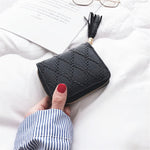 Une main de femme tient un porte-cartes en cuir vintage noir