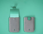 Porte-cartes en cuir gris et intérieur vert.