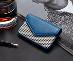 Porte-cartes pour femme en cuir bleu posé sur un livre.