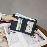 Posé sur un livre ouvert et tenu par une main féminine, ce modèle est montré de face avec des cartes des billets dedans.
