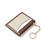 Sur fond blanc se trouve le porte-cartes en cuir marron avec une poche beige.