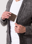 Un homme met le porte-cartes de crédit marron dans sa poche.