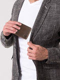Un homme met le porte-cartes de crédit marron dans sa poche.